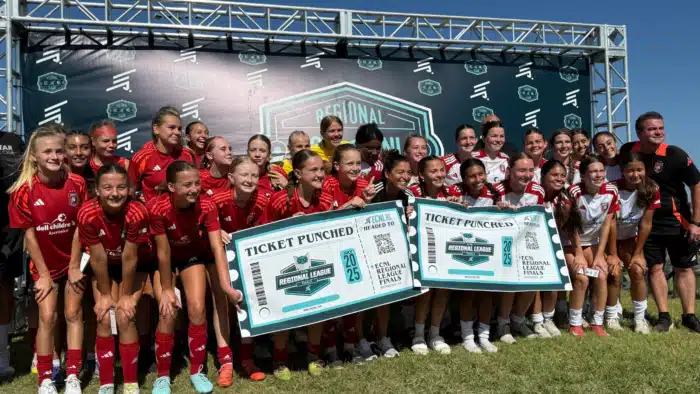 Girls soccer teams celebrate qualifying for regionals holding ticket signs at a sports event backdrop.