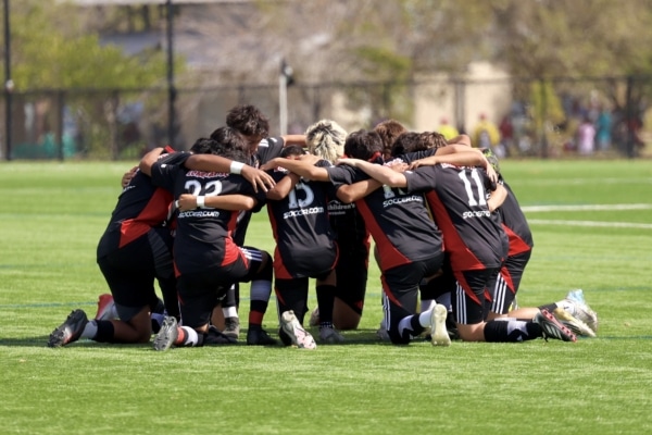 Soccer team huddling on grass field before match day