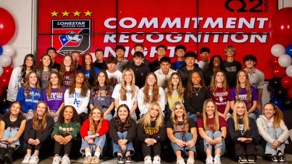 Group of young athletes at a commitment recognition event with Lonestar Soccer Club backdrop