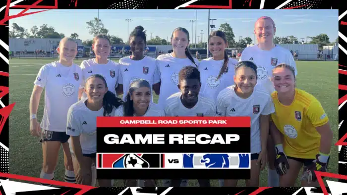 Women's soccer team smiling on the field during game recap at Campbell Road Sports Park