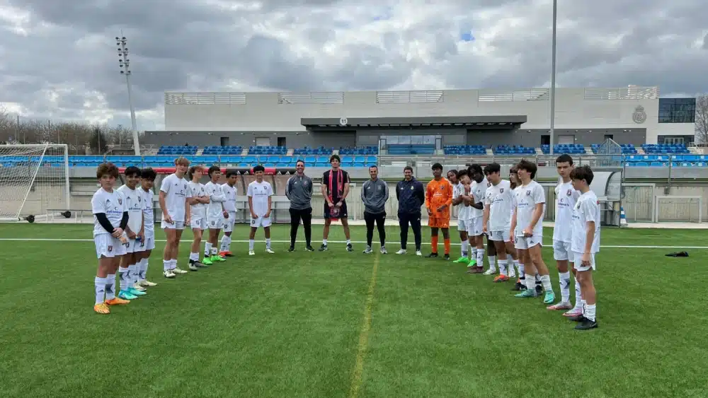 Youth soccer teams facing each other on the field before a match on a cloudy day