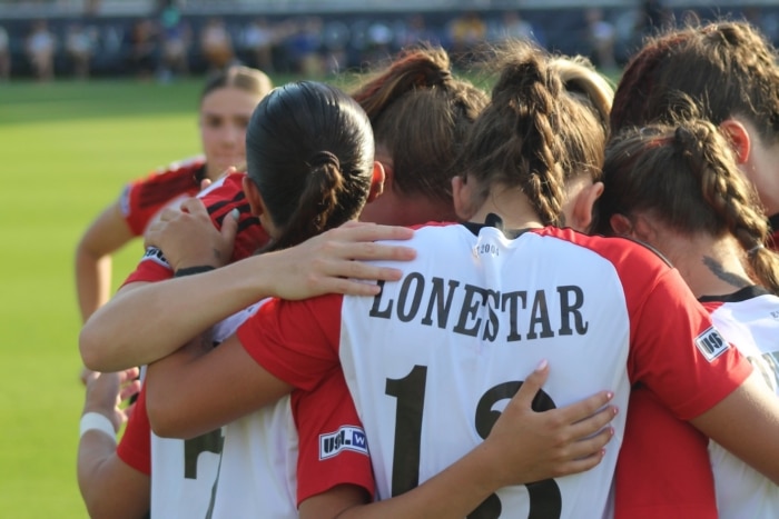 Soccer team huddling on the field before a match